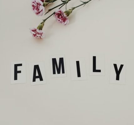 Elegant arrangement of pink flowers and family text on a white background, ideal for family themes.