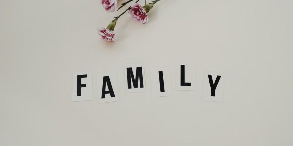 Elegant arrangement of pink flowers and family text on a white background, ideal for family themes.