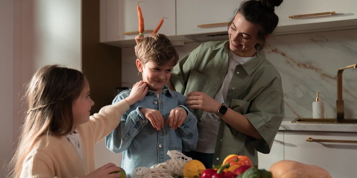 Mother and children have fun unpacking vegetables in the kitchen.