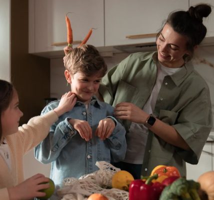 Mother and children have fun unpacking vegetables in the kitchen.